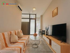 a living room with a couch and a flat screen tv at TPHomes 12 - The Sun Avenue in Ho Chi Minh City