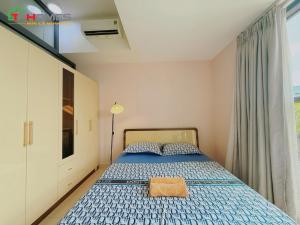 a bedroom with a bed with a blue comforter at TPHomes 12 - The Sun Avenue in Ho Chi Minh City +39 photos