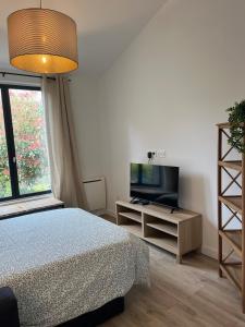 a bedroom with a bed and a flat screen tv at La Renardière in Foreste