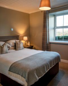 a bedroom with a bed and a window at Vaughans Anchor Inn in Liscannor