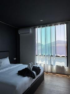 a bedroom with a bed and a large window at Atrium Kathu Hotel in Ban Kathu (1)