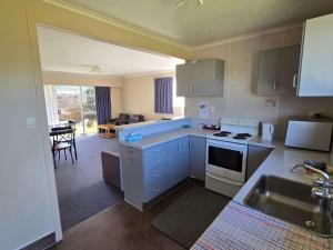 a kitchen with a sink and a stove top oven at Alpenhorn Motel in Te Anau