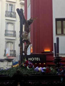 a statue of a man on a cross in front of a hotel at Hotel Paula Films Collection in Mérida