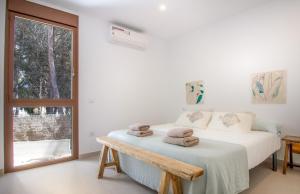 a white bedroom with a bed with towels on it at MARETA - Managed by Almarina in Teulada +46 photos