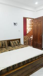 a bedroom with two beds and a wooden door at Ruk Mountain Hotel in Kengalla