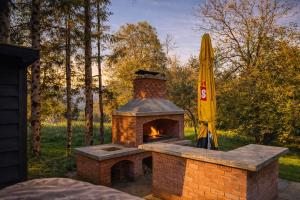 a brick oven with a umbrella and a yellow umbrella at KVillas in Severin na Kupi