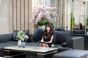 a woman sitting on a couch with a table at Kay Han Riverfront Hotel Da Nang in Danang +16 photos