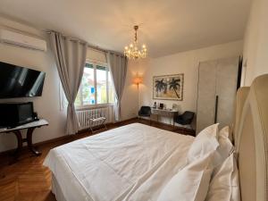 a bedroom with a white bed and a television at Ca Nart in Venice-Lido