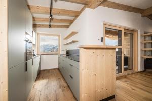 a kitchen with white walls and wooden ceilings at Ahorn Studios in Finsing