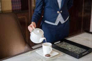 a man in a suit pouring coffee into a cup at The St. Regis Shenzhen in Shenzhen +67 photos