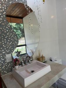 a bathroom with a white sink and a mirror at Chalé Garden - Pedra Azul in Domingos Martins +31 photos