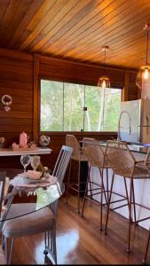a kitchen with a table and chairs in a room at Chalé Garden - Pedra Azul in Domingos Martins