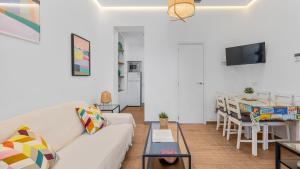 a living room with a white couch and a table at Apartamentos Alcazaba in Málaga