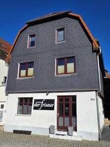 a large white building with a black roof at Apartment Me-Time in Bad Salzungen