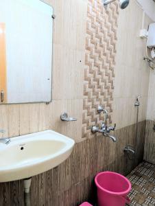 a bathroom with a sink and a pink bucket at Hotel Rukmini Residency, Kolhapur in Kolhapur +40 photos