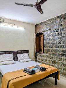 a bedroom with a bed and a brick wall at Hotel Rukmini Residency, Kolhapur in Kolhapur