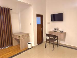 a room with a chair and a desk and a television at The Dimora Residence in Kurunegala +16 photos