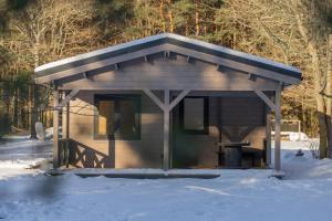 a small cabin with a roof in the snow at Mežmaļi in Jūrkalne +16 photos