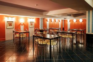 a dining room with tables and chairs and orange walls at Magnolia Tbilisi in Tbilisi City