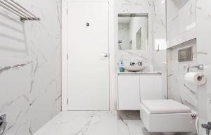 a white bathroom with a sink and a toilet at Relax and Retreat Studio Flat in Glenwood +4 photos