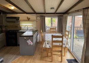 a kitchen and dining room with a table and chairs at Lodge 18 - Caer Beris Park - No Tradesmen in Builth Wells