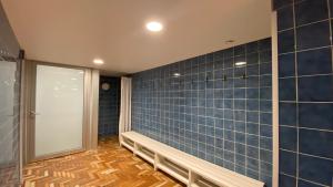 a bathroom with blue tiled walls and a door at Studio SISI in Tauplitz +17 photos