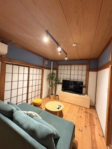 a living room with a couch and a flat screen tv at 城北ノイエ by mooi in Aizuwakamatsu