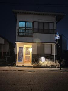 a house with a door on a street at night at 城北ノイエ by mooi in Aizuwakamatsu