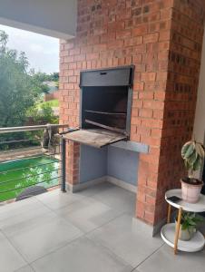 a brick wall with a pizza oven on a patio at Goodman's Guest home in Nelspruit