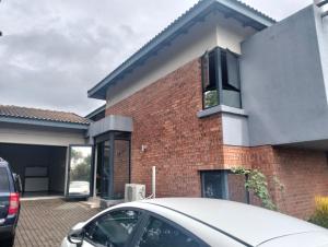 a brick house with a car parked in front of it at Goodman's Guest home in Nelspruit +4 photos