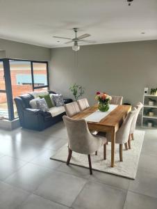 a living room with a wooden table and a couch at Goodman's Guest home in Nelspruit