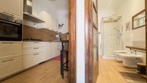 a kitchen with white cabinets and a sink and a toilet at Veranda Liberty, luxury apartment in La Spezia +44 photos
