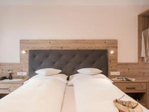 a large bed with two white pillows on it at Hotel Finkenbergerhof in Finkenberg