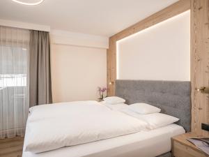 a bedroom with a white bed with a large window at Hotel Finkenbergerhof in Finkenberg +85 photos