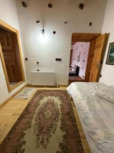 a bedroom with a bed and a rug at Osmanil Konağı in Aksiki