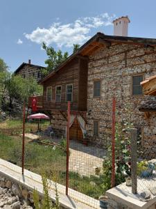a stone house with a fence in front of it at Osmanil Konağı in Aksiki