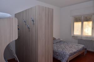 デルヴィオにあるCasa di Leoのベッドルーム1室(ベッド1台付きの大きな木製キャビネット付)