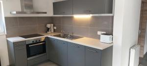 a small kitchen with a sink and a stove at Coolappart in Mont-Saint-Guibert