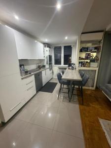 a kitchen with white cabinets and a table and chairs at appartement 65m in Châtillon
