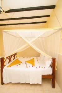a bedroom with a bed with a mosquito net at Kigwedeni Villas in Nungwi +108 photos