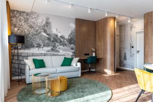 a living room with a white couch and green pillows at LEO Apartman in Veszprém +19 photos
