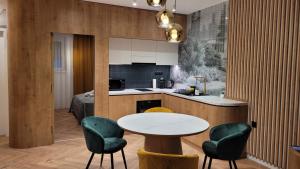 a kitchen with a table and two chairs and a table at LEO Apartman in Veszprém