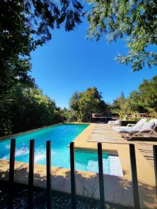 a swimming pool next to a wooden deck at Glamp Refugio Silvestre 7 Tazas in Molina