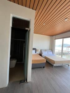 a bedroom with two beds and a wooden ceiling at Destino Beach Resort and Hotel in Batangas City