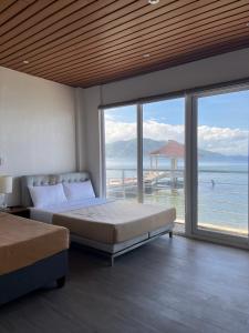 a bedroom with two beds and a view of the ocean at Destino Beach Resort and Hotel in Batangas City