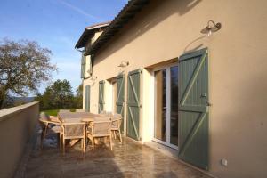a patio with a table and chairs and a building at Villa perchée à Cahors in Cahors
