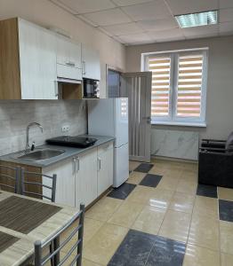 a kitchen with white cabinets and a sink at Апартаменти Пасаж in Skhidnitsa