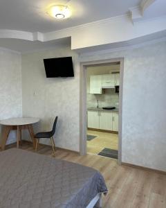 a bedroom with a bed and a table and a television at Апартаменти Пасаж in Skhidnitsa