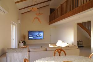 a living room with a couch and a tv on the wall at Villa perchée à Cahors in Cahors