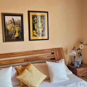 a bedroom with a bed with two pictures on the wall at Winzerhof Gietzen in Hatzenport